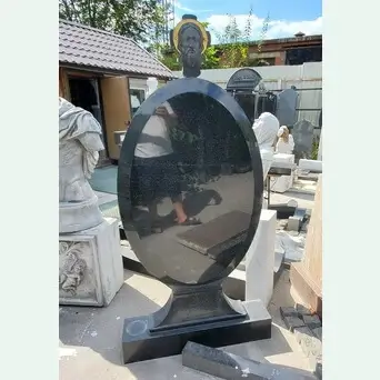 Памятник овальной формы на подставке с ликом святого